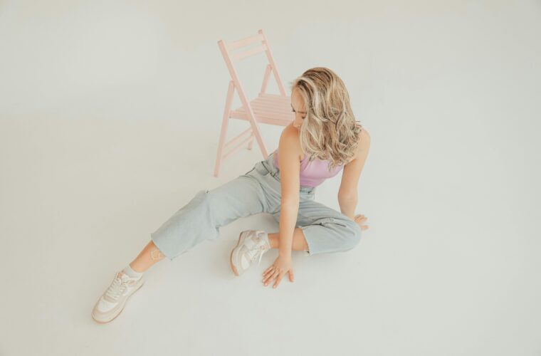 kobieta w jeansach, różowej koszulce i sneakersach